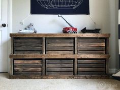 a wooden dresser with drawers in front of a wall hanging on the wall above it