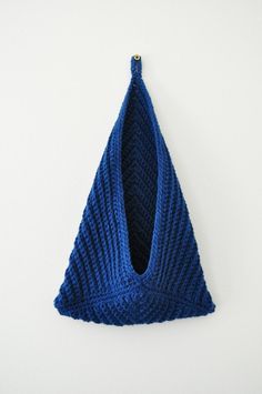 a blue knitted triangle hanging on the wall