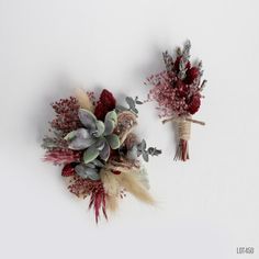 two bouquets of dried flowers sitting on top of a white surface with red and green stems