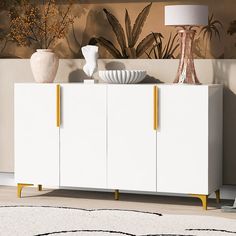 a white sideboard with yellow handles and two vases on top