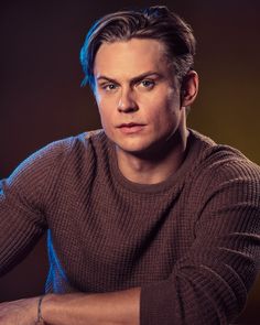 a man sitting at a table with his arms crossed