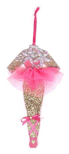 a pink and gold christmas ornament hanging from a string on a white background