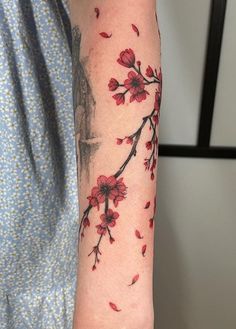 a woman's arm with red flowers on it