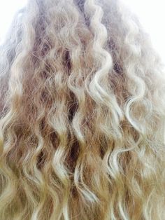 the back of a woman's head with long, curly hair