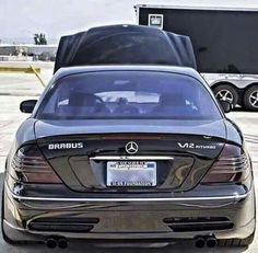 the back end of a mercedes s - class sedan parked in front of a trailer