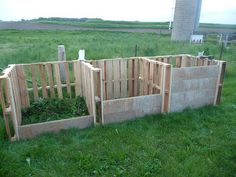 several wooden boxes sitting in the grass next to each other on top of a field