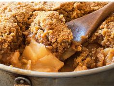 a wooden spoon in a metal pot filled with apple crumbled dessert toppings