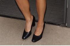 a woman's legs and shoes are shown in front of a door