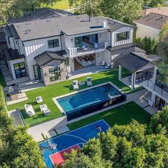 an aerial view of a large house with a swimming pool in the middle of it