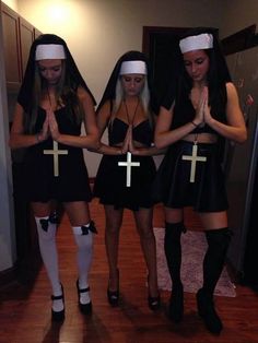 three girls dressed up in black dresses and white headbands with crosses on them