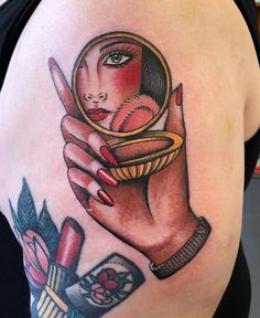 a woman's arm with a tattoo on it and a magnifying glass in her hand