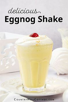 an eggnog shake on a plate with a cherry garnish in it