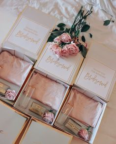 pink roses are sitting on the bed next to boxes with personalized items in them