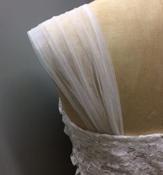 the back of a dress with white lace on it