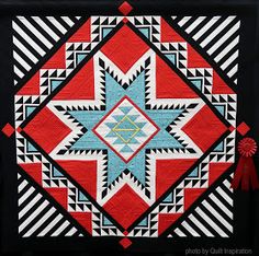 a red, white and blue quilt with an arrow on the center is displayed in front of a black background