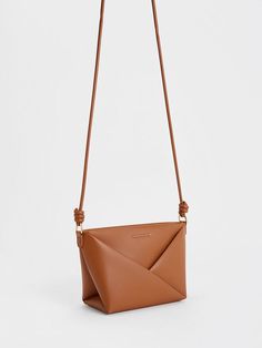 This product is made with at least 20% sustainable materials by weight. CHARLES & KEITH uses recycled, degradable, organic, and water-based materials in our eco-conscious collection. From the luxurious tan finish to the intricate details, this Midori bag will be a stunning addition to your wardrobe. Featuring eye-catching geometric folds and complementary sculptural knots on the straps, this striking design balances distictive details with a clean, elegant silhouette. Equipped with a zip closure that will keep your valuables secure, it is a stylish and practical carrier that will elevate any outfit you pair it with. Brand Collaboration, Charts For Kids, Size Chart For Kids, Charles Keith, Printables Kids, Kids Gifts, Belt Size, Trending Shoes, Comfortable Shoes