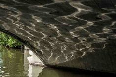 an image of water under a bridge with trees in the background