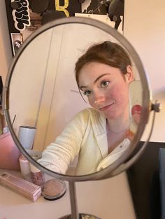 a woman is looking at herself in the mirror