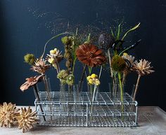 flowers are arranged in vases on a wire rack