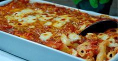 a close up of a casserole dish with pasta and sauce in it, on a table