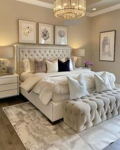 a large white bed sitting in a bedroom on top of a hard wood floor