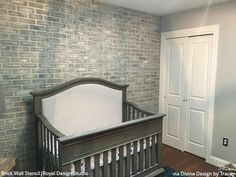 a baby crib in the corner of a room next to a white door and brick wall