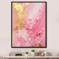 an abstract painting in pink and gold on a wall above a white table with two vases