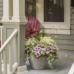 a planter filled with flowers sitting on the front porch