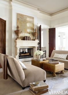 a living room filled with furniture and a fire place in the middle of the room