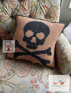 a crocheted pillow with a skull and crossbones on it sitting in a chair