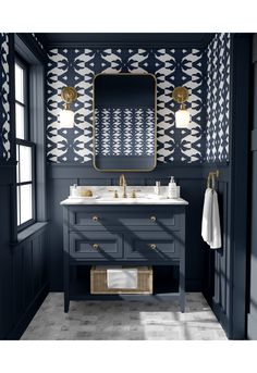 a bathroom with blue and white wallpaper, two sinks and a gold framed mirror