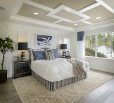 a large white bed sitting in a bedroom next to a window