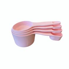 six pink plastic bowls stacked on top of each other with spoons in the middle