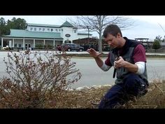 a man kneeling down next to a bush