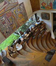 an aerial view of the inside of a building with wooden stairs and paintings on the walls