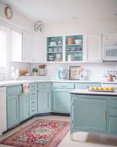 a kitchen with blue cabinets and an area rug