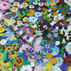 the fabric is colorful and has many different flowers on it, as well as an image of