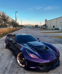 a purple sports car parked in front of a building