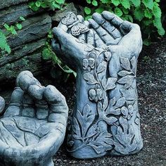 two cement planters sitting next to each other in front of some plants and rocks