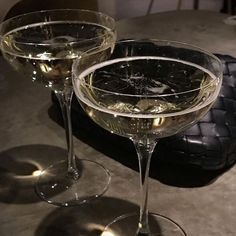 two wine glasses sitting on top of a table