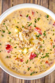 a white bowl filled with soup on top of a wooden table