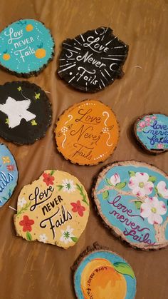 there are many decorated cookies on the table with words written on each one and flowers painted on them