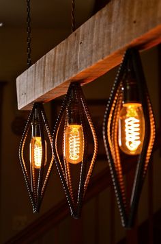 three light bulbs hanging from a wooden beam