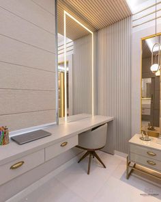 a white desk with a laptop on top of it next to a dresser and mirror