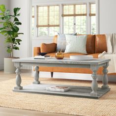 a living room with a couch, coffee table and rugs on the hardwood floor