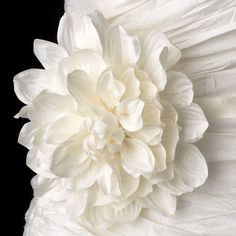 a white flower that is on the back of a dress