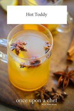 hot toddy in a glass mug with cinnamon and anise on the side