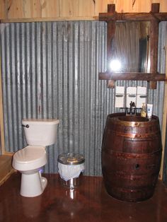 a bathroom with a wooden barrel next to a toilet and sink in it's corner