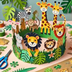 a paper crown with animals and giraffes on it, surrounded by cut outs