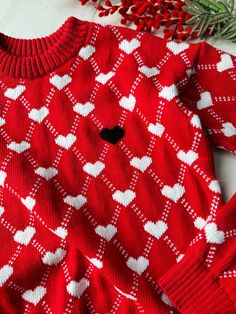 Hand-knitted red hand-knitted sweater with white hearts and one black heart on the chest. This sweater is hand knitted in soft merino wool or cotton. The model of the sweater is loose, with a lowered shoulder. You can order in any size or make changes to your order in the section - personalization. It is also possible to choose a different color for the base color of the sweater. Pictured is size S. Size Parameter: Size XS: length - 58 cm, width 46 cm Size S: length - 60 cm, width - 48 cm Size M Red Long Sleeve Sweater With Heart Print, Winter Heart-shaped Sweater With Heart Print, Winter Heart Print Sweater, White Heart Sweater For Winter, Fitted Winter Top With Heart Print, Fitted Heart Print Sweater For Fall, Knit Crew Neck Sweater With Heart Print, Heart-shaped Knit Sweater For Winter, Cozy Winter Sweater With Heart Print